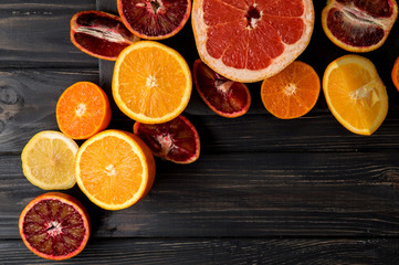 Top view, flat lay, macro. Sliced juicy oranges, tangerines, grapefruit. Dark background. Copy...