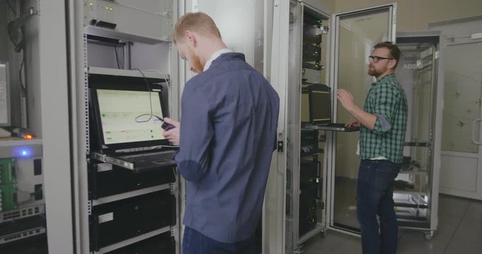 two technicians arrange work in server room