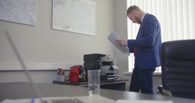director prints on printer in office.