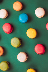 Colorful macaroons assorted on green background