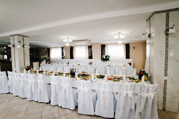 Served table with food. Festive table. Side view. Wedding table, food, drinks, water. Table with silver and glass stemware at restaurant before starting to celebrate.