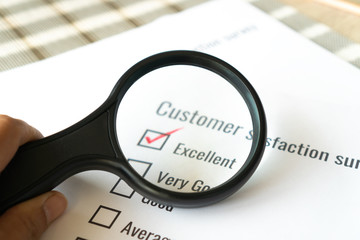 Survey form feedback satisfaction concept: Customer use magnifying glass for checklist excellent over application form document. Opinion question choice fill checkmark for business marketing research