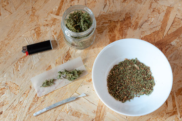 marijuana cigarette, produced with hemp tops, rolling paper and lighter, illegal use of narcotic substance