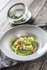 Fusilli pasta with green peas ham and walnuts. italian or mediterranean cuisine