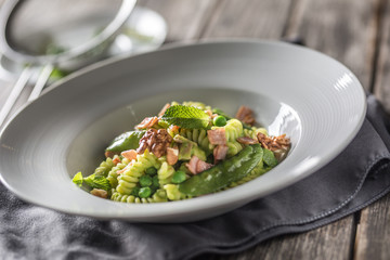Fusilli pasta with green peas ham and walnuts. italian or mediterranean cuisine