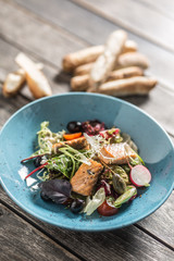 Fresh vegetable salad with roasted salmon olive oil and baguette