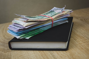 American dollars, euros, rubles are on a black notebook. The concept of a financial plan for the year, investment or saving money. wooden background