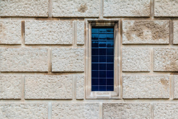 A window on the stone facade of the historic building front view closeup, Barcelona, Catalonia, Spain