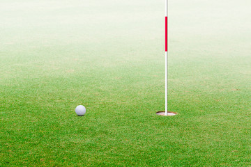 Obraz premium golf ball hole on a field