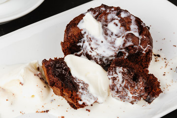 Dessert with hot chocolate muffin and ice cream on a black background.