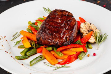 Fried pork with vegetables: green beans, carrots, paprika, garlic, greens, tomato and a glass of red wine,