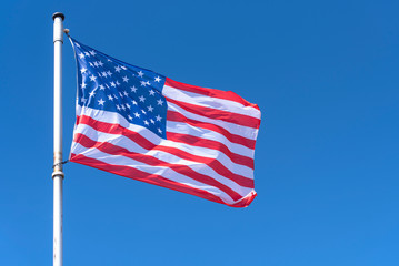 American Flag waving against blue Sky, USA Flag waving as Background