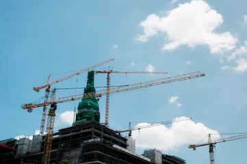 Cranes,construction crane equipment over building construction site on blue sky background