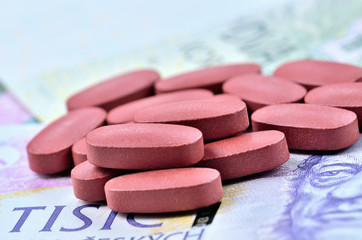 Tablets on Czech banknotes - medical or pharmaceutical industry business finance concept