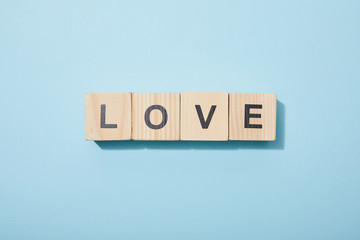 top view of wooden cubes with letters on blue surface