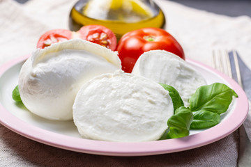 Soft white Italian cheese Mozzarella buffalo served with fresh tomato, olive oil and green basil...