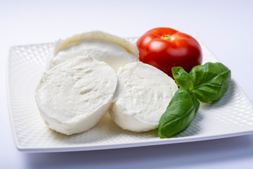 Soft white Italian cheese Mozzarella buffalo served with fresh tomato and green basil leaves