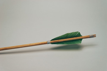 Old wooden arrow. Beautiful gray background. Medieval weapons are handmade.