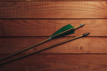 Old wooden arrow. Beautiful wooden table background. Medieval weapons are handmade.