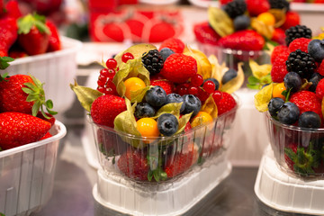 Showcase with set ready to go with different types of delicious berries. Raspberry, strawberry, blueberry,  physalis, cowberry, blackberry.