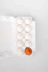 Group of raw eggs white and brown. Concept of diversity, isolation, racism, inequality. On gray background. Top view