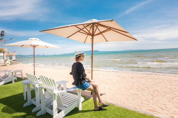 Beautiful woman is relaxing on the beach , under umbrella