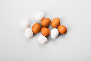 Group of raw eggs white and brown. Concept of diversity, isolation, racism, inequality. On gray background. Top view