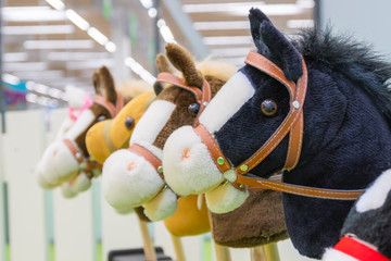 Row of multicolored hobbyhorses - children toys.