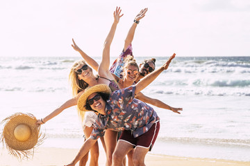 Happy cheerful group of young people friends having fun together in friendship at the beach with...