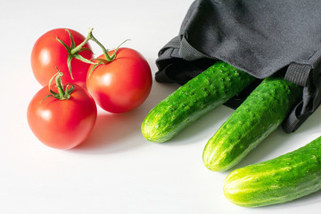 Close-up of fresh, ripe tomatoes and cucumbers on a wood background