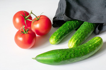 Close-up of fresh, ripe tomatoes and cucumbers on a wood background
