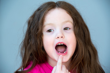Girl 4-5 years old shows a fallen tooth