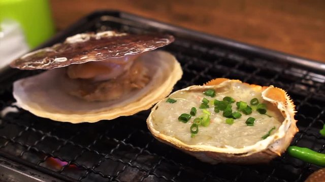 Japanese kani miso in crab shell and scallop grilling in restaurant