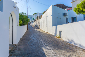 Street view of Plaka picturesque village with paved alleys and traditional houses in Milos island in Cyclades, Greece