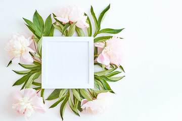 Mockup square white frame with light pink peonies on a white background