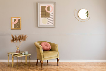 Stylish and luxury living room of apartment interior with elegant green armchair, retro tables,...