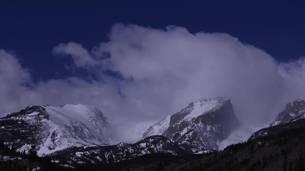 Beautiful time lapse of rolling fog coming off the mountain tops of the rocky mountains, snow covered peaks national park