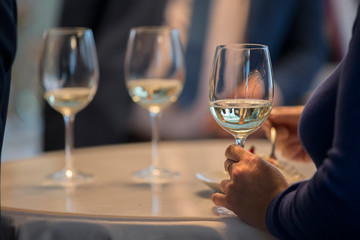 Woman's hands holding a glass of champagne in which the silhouette of a man is reflected. Love concept