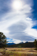 Vertical landscape of sky, sun, cloud formation, grassland field prairie, magnificent shaped storm...