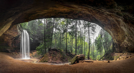 Inside Ash Cave Panorama - Located in the Hocking Hills of Ohio, Ash Cave is an enormous sandstone recess cave adorned with a beautiful waterfall after spring rains. - obrazy, fototapety, plakaty