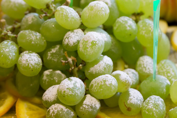 Green grapes with powdered sugar. Fruit dessert