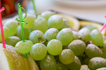 Green grapes with powdered sugar. Fruit dessert