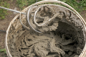 Mixing of concrete in a bucket at a construction site 