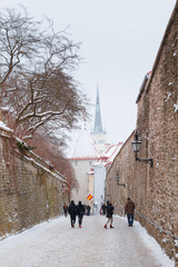 Streets of old Tallinn in winter. Oleviste church tower at the backgrond