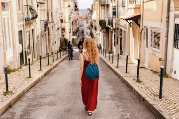 Crédence de cuisine en verre imprimé Madrid Woman in red dress exploring narrow streets of european city streets