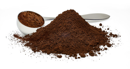Metallic coffee measuring scoop with ground coffee pile isolated on white background