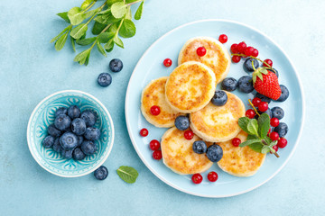 Fototapeta na wymiar Cottage cheese pancakes, syrniki with fresh berries for breakfast