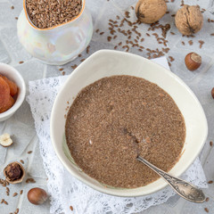 A small plate with flax porridge and nuts. The concept of healthy eating. Selective focus.