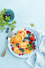Cottage cheese pancakes, syrniki with fresh berries for breakfast