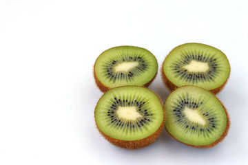 Fototapeta premium Kiwi halves are located on a white background